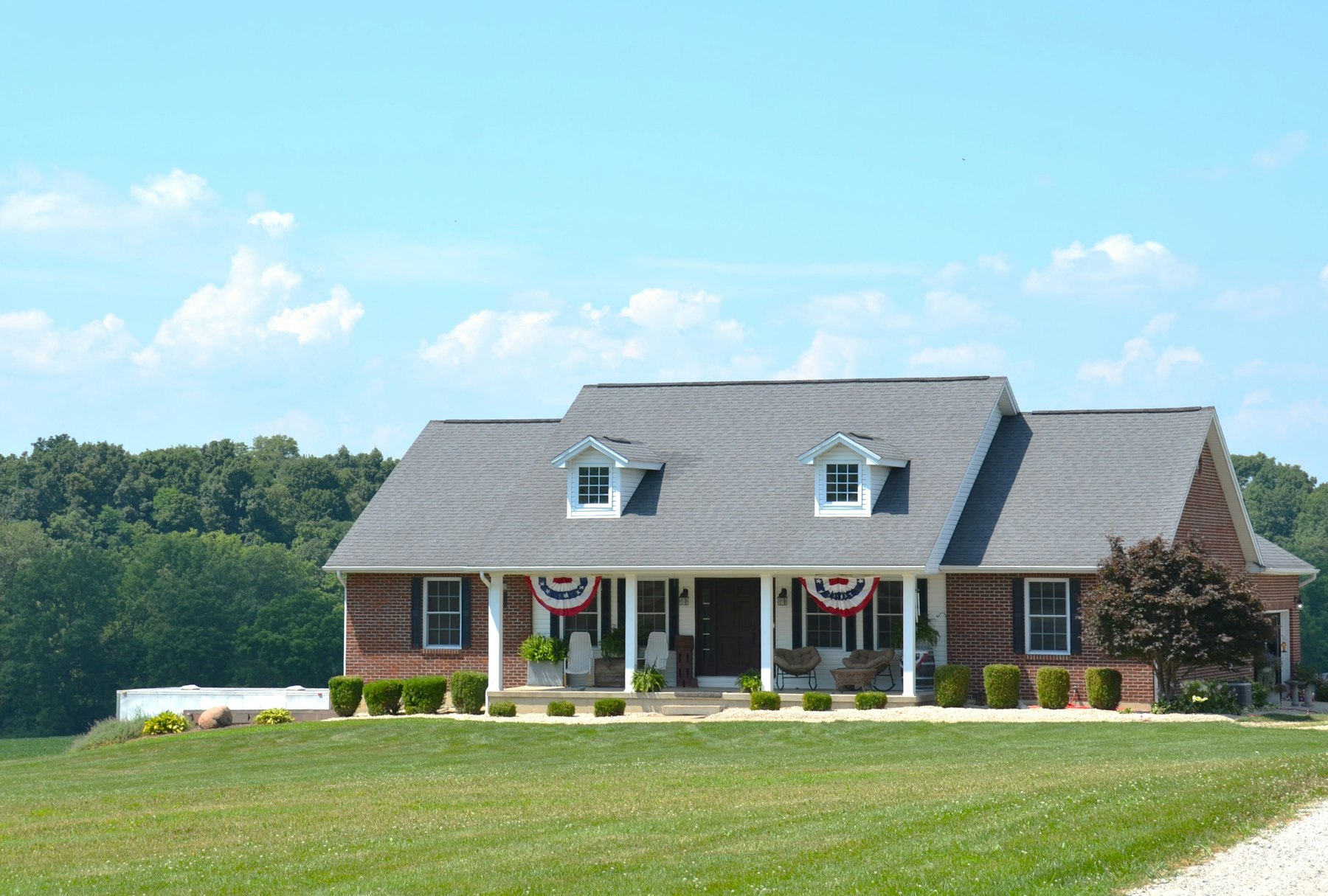 A single-story brick ranch house with a covered porch and dormers behind a green front lawn, the housing type common across Marietta and Cobb County